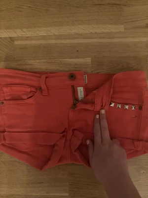 corall rosa shorts med nitar från Lucky brand  - Snygga corall shorts från Lucky brand med coola silvriga nitar på ena fickan. Klassisk femficksmodell med 