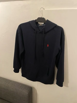 Ralph Lauren XS  - Tjenare säljer denna Ralph Lauren tröja för den är för liten. Den är u storlek XS Herr. På ena snöret så är det lite sönder. Snörerna går att byta.Ner till i resåren har den töjts ut lite. Annars inga andra skador. Därför jag säljer den för lite mindre pris än andra hoodies.