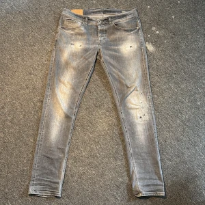 Dondup George Jeans - Gråa slitna eftertraktade Dondup George jeans - Storlek är W34 men sitter som W33 - Skick 9/10 - Nypris 3999kr - Passar bra på dig runt 180-185cm. Kontakta vid frågor eller liknande!