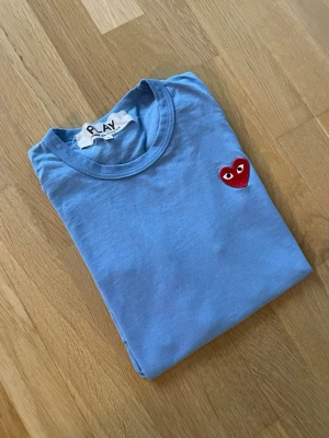 Blå Comme des Garçons Play t-shirt - Snygg Blå Comme des Garçons Play t-shirt i storlek S. Nypris ca 900kr mitt pris endast 249kr. Fraktar inom 1 dag, om du har någon fundering så är det bara att höra av sig😊