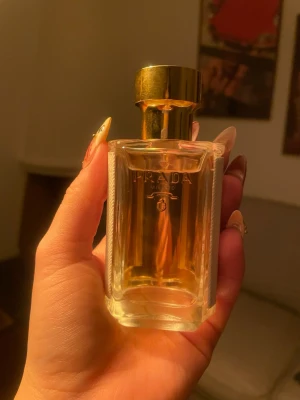 Prada Amber Pour Femme parfym 35ml - Elegant parfym från Prada i en genomskinlig glasflaska med guldfärgat lock. Flaskan har raka linjer och en lyxig känsla, och rymmer 35 ml. Doften är Amber Pour Femme, en klassiker för dig som gillar exklusiva och varma toner.