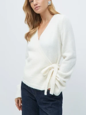 vit knyt kofta - Säljer en vit stickad omlotttröja med knytband i sidan. Tröjan har v-ringning och långa ärmar, perfekt för att skapa en snygg och avslappnad look. Materialet är mjukt och skönt, passar bra till jeans eller leggings.