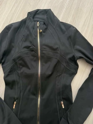 Lululemon define jacket  - Lululemon träningsjacka 🖤  Svart, figurnära och sitter riktigt snyggt. Stretchigt material som är superbekvämt ✨  • Guldfärgad dragkedja • Fickor med dragkedja • Perfekt till gym eller vardag