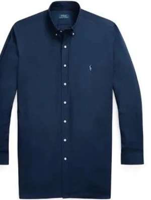 Mörkblå skjorta från Polo Ralph Lauren - Klassisk mörkblå skjorta från Polo Ralph Lauren med lång ärm och knappar framtill. Skjortan har en liten broderad logga på bröstet och en stilren, tidlös design. Perfekt för dig som gillar en clean och snygg look.