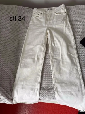 Vita raka jeans från Lager157 - Säljer ett par vita jeans från Lager157 med rak passform och hög midja. Klassisk femficksmodell med dragkedja och knapp framtill. Perfekta för en clean och fräsch look. Materialet är kraftigt denim i bomull. De är helt oanvända. 