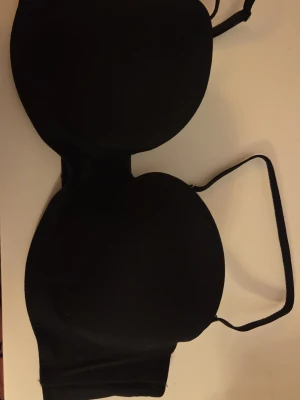 Svart bh med avtagbara band - Stilren svart bh med släta kupor och avtagbara axelband. Ingen push-up. Perfekt för dig som vill ha en enkel och mångsidig bh under olika plagg. Endast använd en gång. Pris går att diskutera!