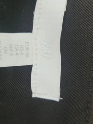Svarta kostymbyxor från H&M - Säljer ett par klassiska svarta kostymbyxor från H&M i storlek 36. Byxorna har rak passform och är tillverkade i ett mjukt, vävt material som ger en stilren look. Perfekta att matcha med skjorta eller kavaj.