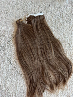 Bruna tape-on löshår extensions 100g - Säljer bruna tape-on löshår extensions i en naturlig, kall brun nyans. Håret är rakt och har en mjuk glans. Perfekt för dig som vill ha längre och fylligare hår. Fästes enkelt med tejp. Material: äkta hår.
