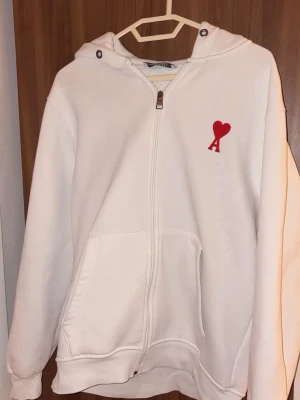 Vit hoodie med röd Ami - Säljer en vit hoodie från Ami. Storlek passar även M