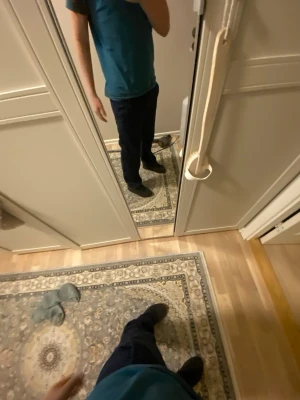 Mörkblå mjukisbyxor med dragsko - Säljer ett par mörkblå mjukisbyxor med resår i midjan och dragsko för skön passform. Byxorna har raka ben och är tillverkade i ett mjukt och bekvämt material, perfekta för chill dagar hemma. Inga synliga loggor eller märken.