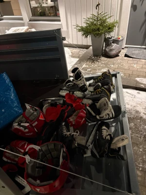 Lite blandat med hockey utrustning. - 4 par skridskor i stora och små storlekar och ett par hockey vantar och benskydd 