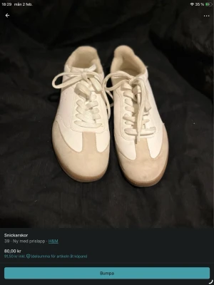 Vita sneakers från H&M med beige detaljer - Stilrena vita sneakers från H&M med beige mockadetaljer och klassisk snörning. Skorna har en retroinspirerad look och passar perfekt till jeans eller kjol. Snygg och enkel design som funkar till många outfits.