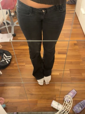 Svarta bootcut jeans Din Vintage Shop - Svarta lågmidjade jeans med bootcut-modell och snygg söm på bakfickan. Jeansen har klassisk femficksdesign och är gjorda i mjukt denimtyg med lite stretch för extra komfort. Säljer då dom ej kommer till andvändning.