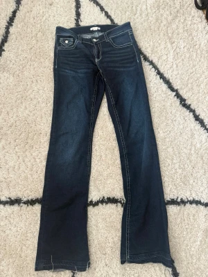 Mörkblå bootcut jeans med kontrastsömmar - Säljer ett. par mörkblå, bootcout jeans med vita sömmar med fina fickor. Inte använt mycket, —> bra skick. Storlek 170 (gina youngs storlekar). 