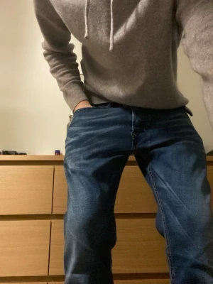 Blå Disel jeans med slitningar från 1978 - Snygga blå jeans från 1978 med markerade slitningar och tvättade detaljer. Klassisk femficksmodell med kontrastsömmar och metallknappar. Jeansen har en rak passform och är tillverkade i denim med cool vintagekänsla.