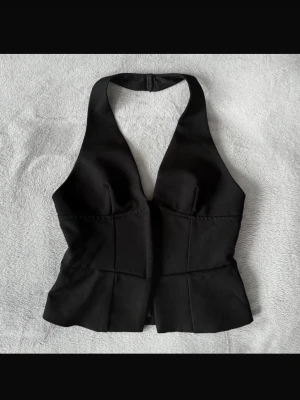 Svart korsett-topp med v-ringning - Snygg topp med v-ringning som man knäpper framtill💞