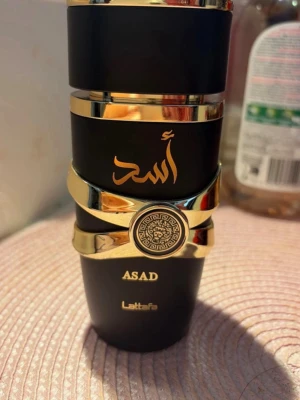 Lattafa Asad parfym svart/guld - Lattafa Asad parfym i en lyxig svart flaska med gulddetaljer och orientaliskt mönster. Använt bokstavligen 4 gånger . Jag beställde hem den och märkte att jag köpte en manlig och inte en kvinnlig doft . Säljer för 150 , köpt för 370