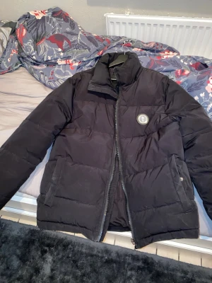 Trapstar Pufferjacka  - Säljer en svart pufferjacka från Trapstar. Denna är en kopia av väldigt bra kvalité, denna ser helt ny ut. Som man ser på bilderna så är luvan av men super enkelt att sätta på den. Säljer denna pga ny stil. Kan sänka priset vid snabb affär. 