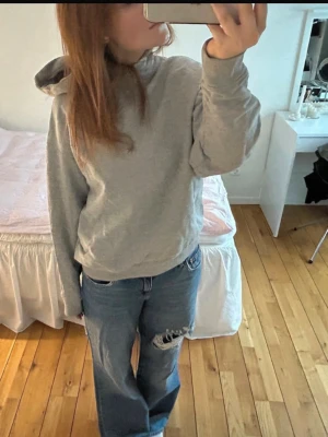 Grå basic hoodie med huva - Enkel och stilren grå hoodie med huva och långa ärmar. Hoodien har en avslappnad passform och är perfekt för en chill och bekväm look. Tillverkad i mjukt material som känns skönt mot huden.