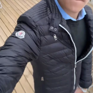Svart pufferjacka från Moncler - Jackan har fått ett hål/repa vid sidan som man ser vid bilden men det går absolut att sy ihop och laga, jag själv har inte årkat det så istället säljer jag en äkta Moncler jacka billigare till nån som vill ha en. Jackan är äkta vilket du kan se med att ta märket på hemsidan och testa det där. Jackan är mörkblå, men ser svart ut på bilderna jag har därför tog jag den första bilden från TikTok på exakt likadan jacka som jag säljer. Säljer en svart pufferjacka från Moncler.