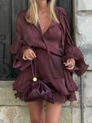 Vinröd omlottklänning med volang - Säljer en vinröd kort omlottklänning med volangdetaljer och långa ärmar. Klänningen har knytband vid halsen. Perfekt som fest/middagsklänning och trendigt plagg. Använd vid ett tillfälle och kan postas idag! Nypris 699 kr