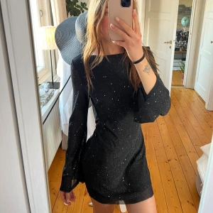Svart glittrig klänning - Svart  klänning med glittriga detaljer och öppen rygg! Superfin och väldigt skön! Använd några gånger bara💕