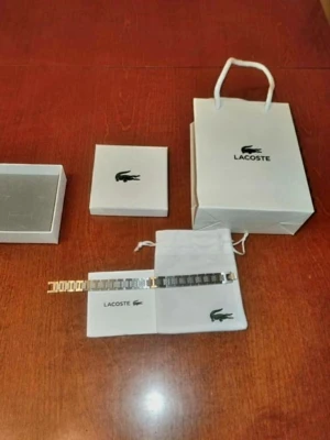 Silverfärgat armband från Lacoste - Stilrent armband i silverfärgad metall från Lacoste med länkdesign och diskreta Lacoste-loggor på länkarna. Kommer med original ask, påse och presentpåse med Lacoste-tryck. Perfekt accessoar för dig som gillar klassisk och sportig stil.