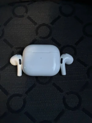 Apple AirPods Pro med laddningsetui - Säljer ett par vita Apple AirPods Pro med matchande laddningsetui. Trådlösa in-ear hörlurar med stilren och kompakt design. Perfekta för musik, poddar och samtal. Laddningsetuiet är också vitt och har en smidig form som är lätt att ta med sig.
