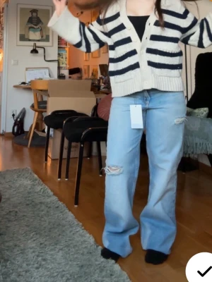 Ljusblå slitna raka jeans - Säljer ett par populära Zara ljusblå jeans med raka ben och slitningar vid knäet. Helt oanvända med prislapp! ❤️