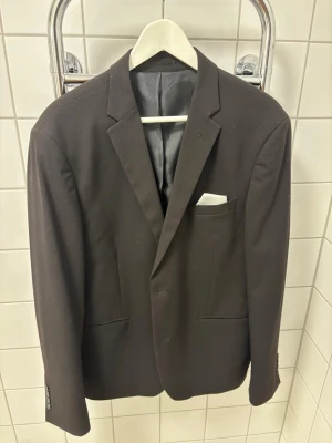 Svart kavaj från Lindbergh White - Stilren svart kavaj från Lindbergh White i modellen Slim Fit. Kavajen är använd vid 2 tillfällen och i toppen skick!