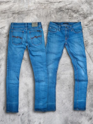 Nudie Jeans  - Säljer ett par riktigt feta Nudie Jeans. Jeansen är ljusblå med orangea sömmar och broderi på bakfickorna. Jeansen har (fades) - och en washad look samt är slimfit. Storlek W-26 och L-32. Plagget har någon enstaka liten fläck som knappt är märkbar(se sista bild). Vid fler frågor skriv gärna i DM😁, Pris är diskuterbart!🙌