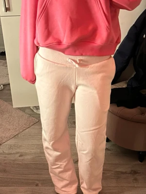 Ljus rosa mjukisbyxor - Säljer ett par ljus rosa mjukisbyxor med rak passform och bred resår i midjan. Byxorna har dragsko för justerbar passform och är tillverkade i ett mjukt, bekvämt material❤️❤️