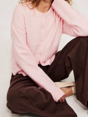 Ljusrosa kofta med rund hals - Söt ljusrosa kofta med rund halsringning och knäppning framtill. Koftan har en avslappnad passform och långa ärmar, perfekt för lager på lager. Enkel och stilren design som passar till det mesta.