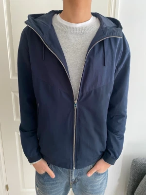 Hugo Boss Windbreaker  - Tjena! Säljer nu denna extremt snygga och sällsynta windbreaker/cardigan från Hugo Boss. Storlek L och i nyskick. Nypris ca 4000! Priset är ej hugget i sten så hör av dig vid minsta fundering:)