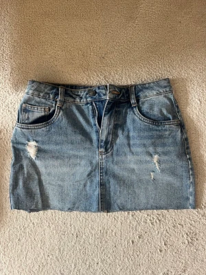 Blå jeanskjol med slitningar🩵🩵 - Snygg blå jeanskjol i kort modell med slitna detaljer framtill🩵🩵 I toppskick och knappt använd! 