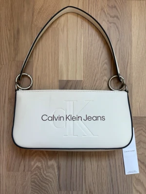 Calvin Klein Jeans baguette bag ny med prislapp  - Vit Calvin Klein Jeans axelväska. Helt ny med prislapp. Nypris 500💕💕