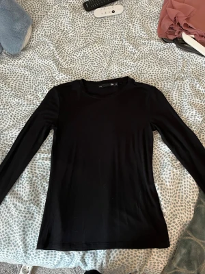 Svart långärmad topp från lager 157 - En enkel och stilren svart långärmad topp från 157. Modellen har rund halsringning och är figurnära i passformen. Ganska ny och inte använd så mycket.