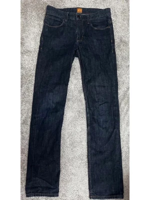 BOSS Hugo Boss Jeans – W30 L34 – Mörkblå - Säljer ett par BOSS Hugo Boss jeans i mörkblå tvätt. Klassisk modell som funkar både till vardag och mer uppklätt.       Storlek W30 L34, Tidlös mörk tvätt, Premium denim, Bra skick                Perfekta jeans för dig som vill ha ett stilrent och kvalitativt plagg från ett välkänt märke.