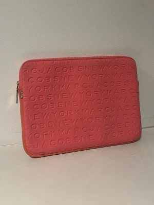 Marc Jacobs datorfodral - Datorfodral från Marc Jacobs. Bra skick men har en liten mindre smutsfläck. Korall färgad och 14 tum.