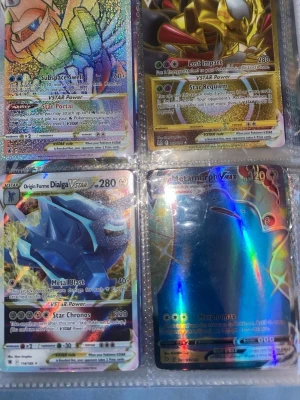 Pokémon VSTAR och VMAX samlarkort - Säljer ett gäng Pokémon VSTAR och VMAX samlarkort med holografisk finish. Bland korten finns Origin Forme Dialga, Metamorph, samt flera andra legendariska och färgstarka Pokémon. Perfekt för dig som vill utöka din samling med exklusiva och glittriga kort! Skicka till mig om du är intresserad och så fick inte alla bilder plats så skicka till mig om du vill se fler bilder. Men om du bara vill ha några kort så kan jag skicka bild på det