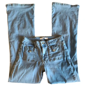 Blåa bootcut/flare jeans, NAKD, hippie/ alt/ 70tal/ 70s - Blåa utsvängda jeans från NAKD, medelhöga/högmidjade, (Obs! Liten defekt finns, lite slitet i fram vid gylfen) Midjemått 67,5cm Grenhöjd 23cm Innerbenslängd 76,5cm Benslut (rakt över) 27cm