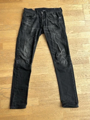 Svarta Dondup Jeans - Säljer ett par svarta slim fit jeans med snygga slitningar och tvättade detaljer. Jeansen är i övrigt bra skick men har en defekt på donduplappen på insidan som inte syns utifrån. Jeansen är i stolen 31. Hör av dig vid frågor!