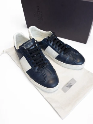 Valentino Garavani Flycrew - 43/44 - Säljer ett par Valentino Garavani Flycrew sneakers i storlek 43, men de är något rymliga och passar även dig som vanligtvis har 44.  Klassisk design i mörkblått med vita detaljer, enkla att matcha både till jeans och en mer uppklädd outfit. Tillverkade i högkvalitativt läder med Valentinos signaturdetaljer.  Skorna kommer med originalbox samt dustbag (se bilder). Saknar en av sina nitar på ena skon längst bak, annars mycket bra skick.  Skriv vid minsta fundering!