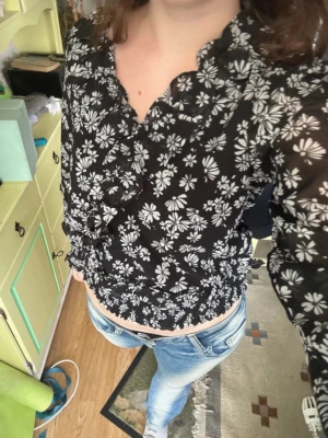 Svart blommig blus med volang - Storleken är 36 (S) men är för liten för mig som vanligtvis är S🙃 Skulle istället säga att den passar XXS-XS🖤🤍  OBS! Pälsdjur finns i hemmet
