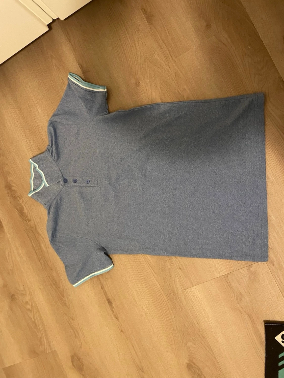 Blå pikétopp med vita detaljer