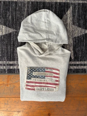 Denim&supply Ralph Lauren Hoodie - Storlek S - Säljer en hoodie från Denim & Supply (Ralph Laurens unika sub-brand som lades ner 2016). Denna modell har en speciell plats i modearkivet och blir bara svårare att hitta med tiden. • Storlek: S • Skick: Mycket gott skick, välvårdad och fint bevarad trots sin ålder. • Äkthet: 100% äkta med original tvättlappar kvar. • Detaljer: Klassisk Denim & Supply-kvalitet. Ingen QR-kod finns på denna modell (vilket är helt korrekt för åldern/märket)