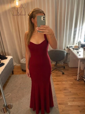 Vinröd långklänning med smala axelband - Vinröd långklänning med smala axelband och figurnära passform (sjöljungfru modell). Köpt för ca 1200kr och endast använd en gång. Perfekt för speciella tillfällen och bal.😊