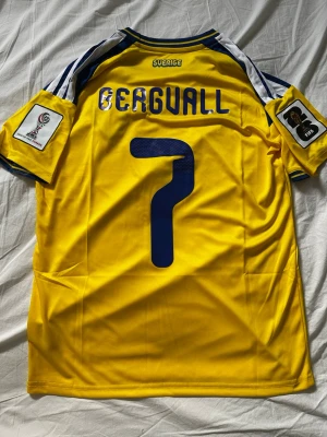 Sveriges VM-hemmatröja, Bergvall nr 7 - Sveriges Vm-hemmatröja med Bergvall nummer 7 på ryggen. Tröjan är helt ny med vm loggorna på axlarna. Tröjan är från adidas med Storlek S. 