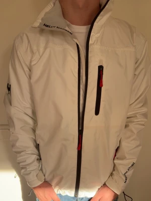 Vit vindjacka från Helly Hansen - Tja! Säljer nu denna feta jacka från helly hansen  Riktigt stilren och passar perfekt till både vardag och sommaroutfits. Funkar till allt och sitter riktigt bra.  Skick: 9/10 Pris: 599 kr (kan diskuteras vid snabb affär 💸)