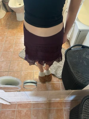 Mörklila volangkjol från Lindex - Säljer en mörklila/vinröd kortkjol från Lindex med volangdetaljer och dragkedja i midjan.